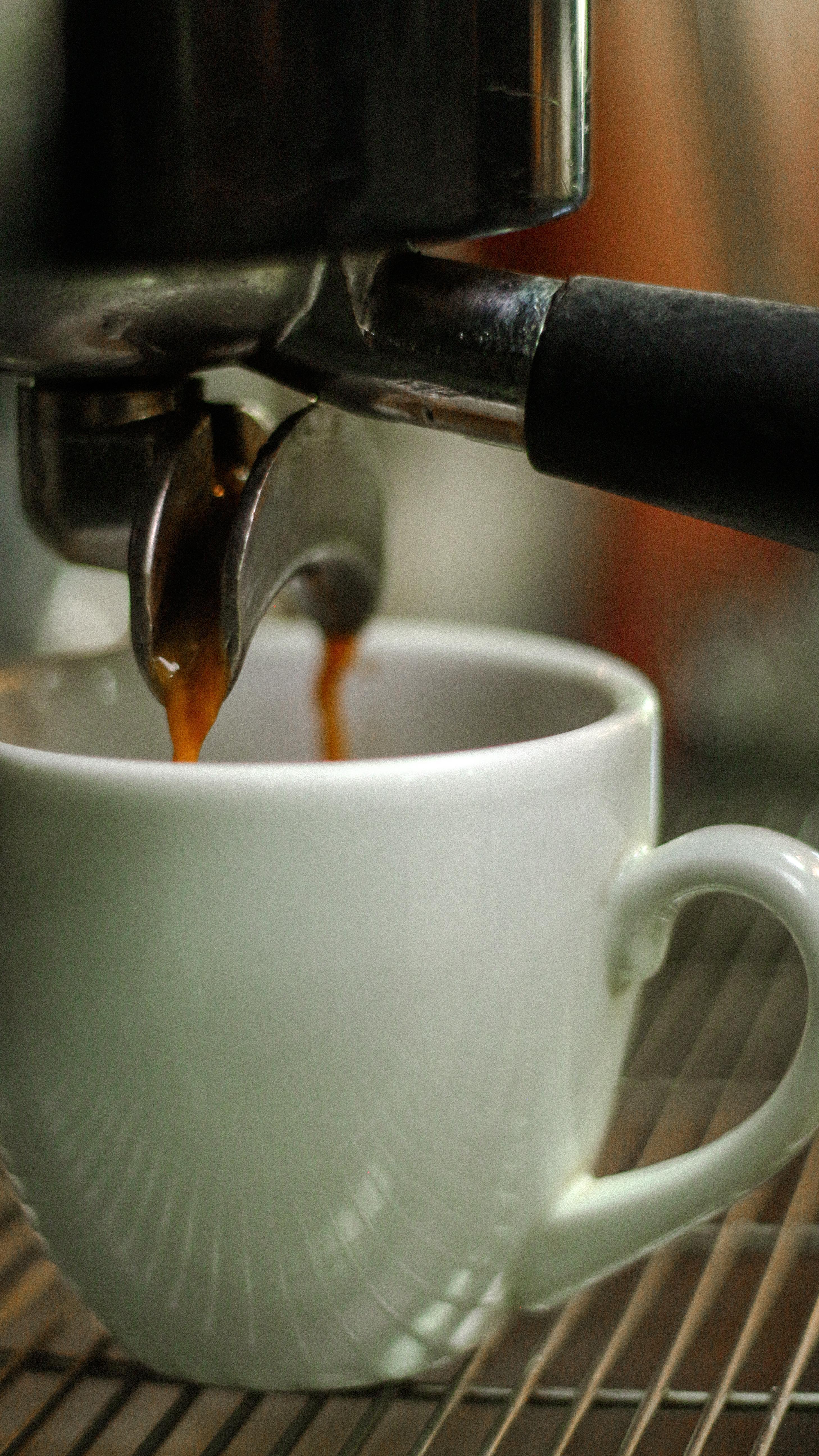 Espresso caindo na xícara branca